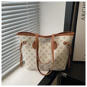 Detailed close-up of premium tote bag with vintage monogram patterns and brown leather straps