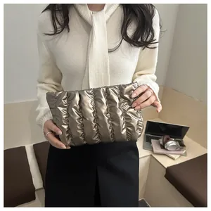 Detail der metallisch bronzenen Falten-Clutch mit vertikaler Stepp-Puffer-Struktur