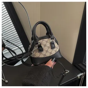 Detail of mini checkered shell bag with leather handles and adjustable shoulder strap