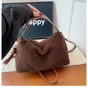 Detail of dark brown plush crossbody bag with lamb wool texture and gold hardware