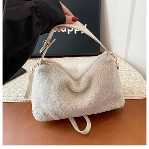Detail of soft cream sherpa teddy fabric and adjustable leather strap with gold hardware
