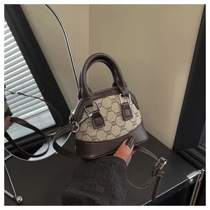 Detail of mini shell handbag with vintage pattern and adjustable crossbody leather strap
