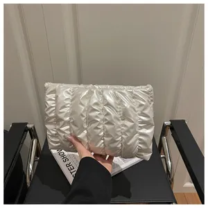 Detailed view of the white pleated cloud clutch with soft quilted satin texture