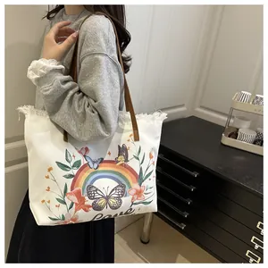 Detail of canvas tote bag featuring floral butterfly print and stylish fringe edges