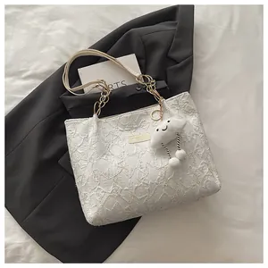 Detail of star-quilted texture on white tote bag with gold chain and cloud charm
