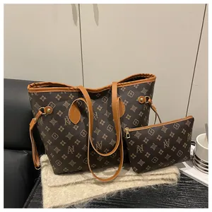 Detail of monogram brown tote bag with matching pouch and premium gold hardware