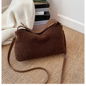 Detail of plush brown teddy fleece tote bag featuring leather straps and gold metal hardware