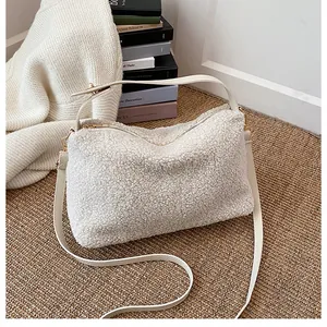 Detail of plush white faux fur handbag texture with zipper and leather strap