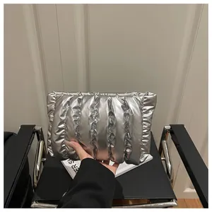 Close-up of metallic silver quilted clutch bag with vertical pleated texture and gloss