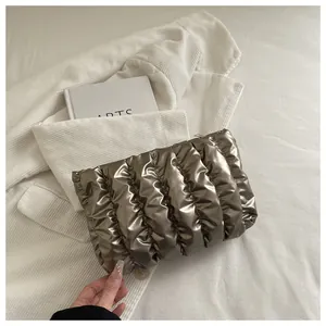 Detailansicht der bronzefarbenen Faltenstruktur und vertikalen Steppung der eleganten Clutch