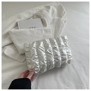 Detail der gesteppten Falten an silberner Perlen-Clutch-Tasche mit Metallic-Textur