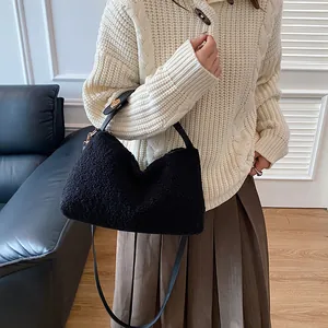 Minimalist black plush square handbag with adjustable strap shown on a model