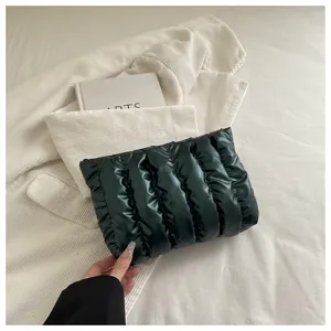 Makroaufnahme einer dunkelgrünen gesteppten Handtasche mit Glanz-Finish auf Kordsamt