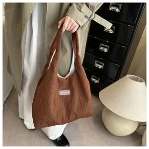 Detail shot of brown pleated fabric texture and fashion label on a slouchy tote bag