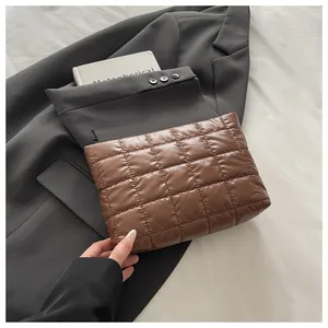 Gros plan détaillé d'une pochette en nylon matelassé marron avec surpiqûres carrées