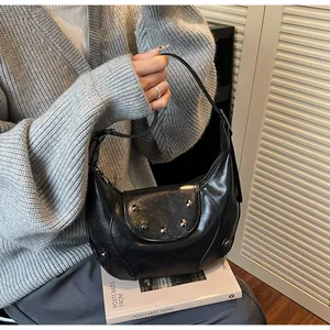 Detail van zwarte hobo-tas met zilveren bolnagels en verstelbare leren schouderriem
