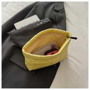 Détail de l'intérieur spacieux d'une pochette matelassée jaune avec fermeture à glissière