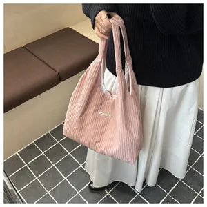 Detail of pink pleated tote bag texture and white FASHION label in a lifestyle setting