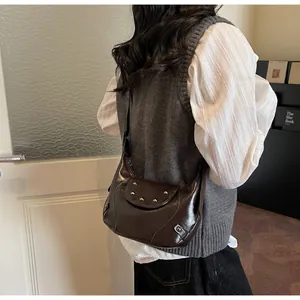 Detailweergave van donkerbruine leren hobo-tas met zilveren studs en gespband