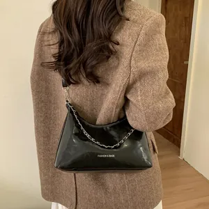 Détail du sac en cuir noir brillant avec chaîne argentée et lettrage Fashion & Bags