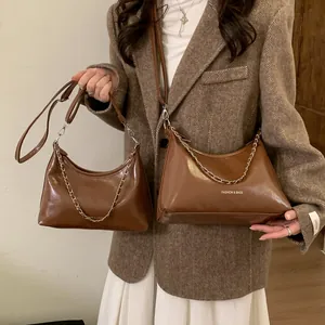 Vue détaillée de deux sacs en simili cuir marron avec chaîne argentée et texte mode
