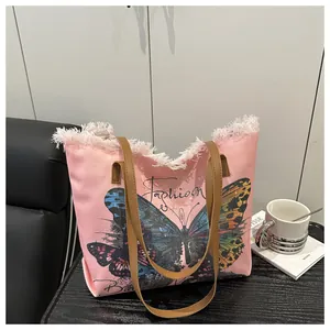 Detailansicht der rosa Canvas-Tasche mit Schmetterlingsdruck und Fransen am Rand