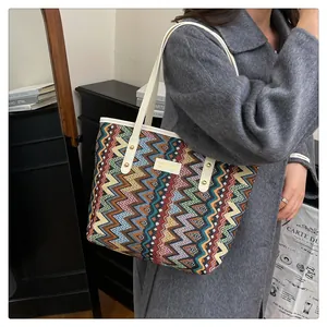 Detail der gewebten Vintage-Tragetasche mit bunten geometrischen Mustern und PU-Griffen
