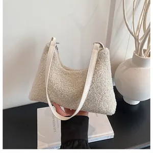 Close-up of fluffy cream teddy tote bag with white PU strap and silver zipper details
