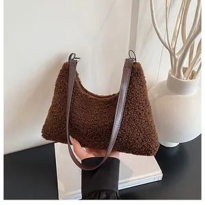 Detail of coffee brown fuzzy faux shearling hobo bag with adjustable leather strap