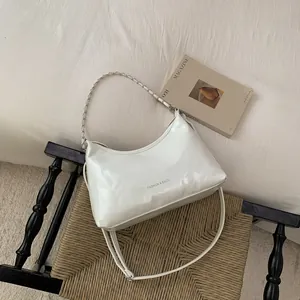 Détail du sac à main blanc brillant en demi-lune avec chaîne argentée et fine bandoulière