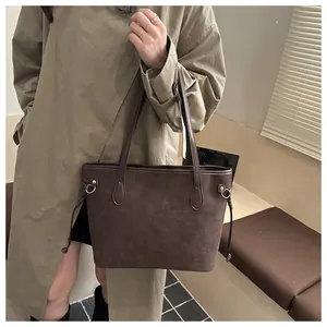 Detailansicht der dunkelbraunen Wildleder-Tote-Bag mit goldenen Metallringen und Riemen