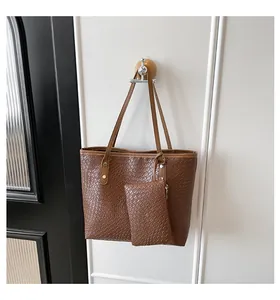 Detail of brown woven texture tote bag with matching hanging pouch and gold rivets