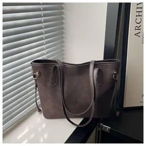 Detail view of large dark brown suede tote bag with side drawstring and metal hardware