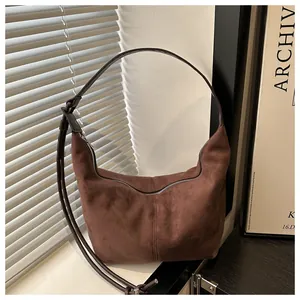 Close-up of a vintage brown suede hobo bag with a smooth zipper and long shoulder strap