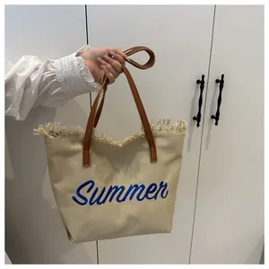 Détail de la broderie Summer et des franges sur ce sac cabas en toile blanc cassé