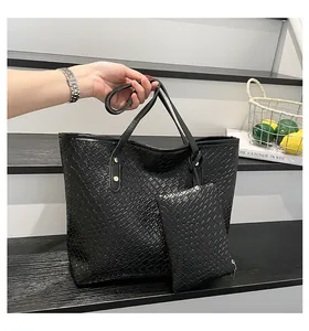 Black woven tote bag set featuring a matching zipper pouch on a minimalist step display