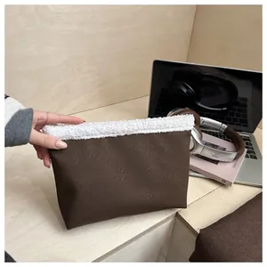 Dettaglio della borsa in ecopelle con bordo in peluche bianco e trama marrone liscia