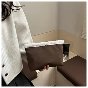 Dettaglio della borsa a mano in finta pelle marrone con bordo in ecopelliccia