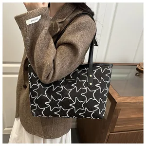 Detail of black tote bag with white star pattern texture and brand logo for daily use