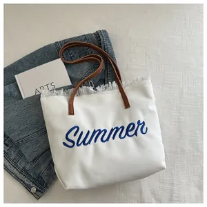 Détail de la broderie Summer et bords effilochés sur cabas en toile avec anses en cuir
