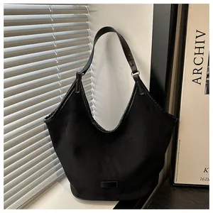 Détails de ce sac hobo noir en daim avec bandoulière en cuir et anneau métallique