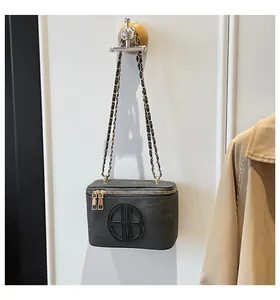 Détail du sac carré gris foncé avec double fermeture éclair dorée et bandoulière chaîne