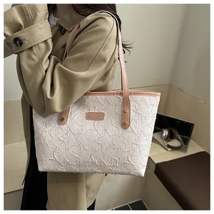 Detail of light pink tote bag featuring star embroidery and leather shoulder strap