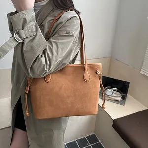 Braune Shopper-Tasche aus Wildleder mit Kordelzug für Damen an der Schulter getragen