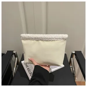Dettaglio borsa tote in ecopelle crema con bordo in peluche bianco tenuta su sfondo neutro
