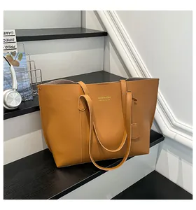 Detailed view of brown leather tote bag with elegant handles on minimalist black steps