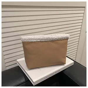 Dettaglio di pochette in pelle color cammello con bordo in ecopelliccia bianca