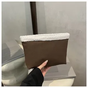 Dettaglio pochette marrone scuro con bordo in morbido pile bianco e finitura opaca