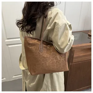 Detail shot of a brown leopard print tote bag in soft suede fabric with slim shoulder straps
