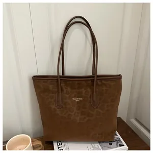 Close-up of leopard print tote bag with gold branding on a wooden table setup